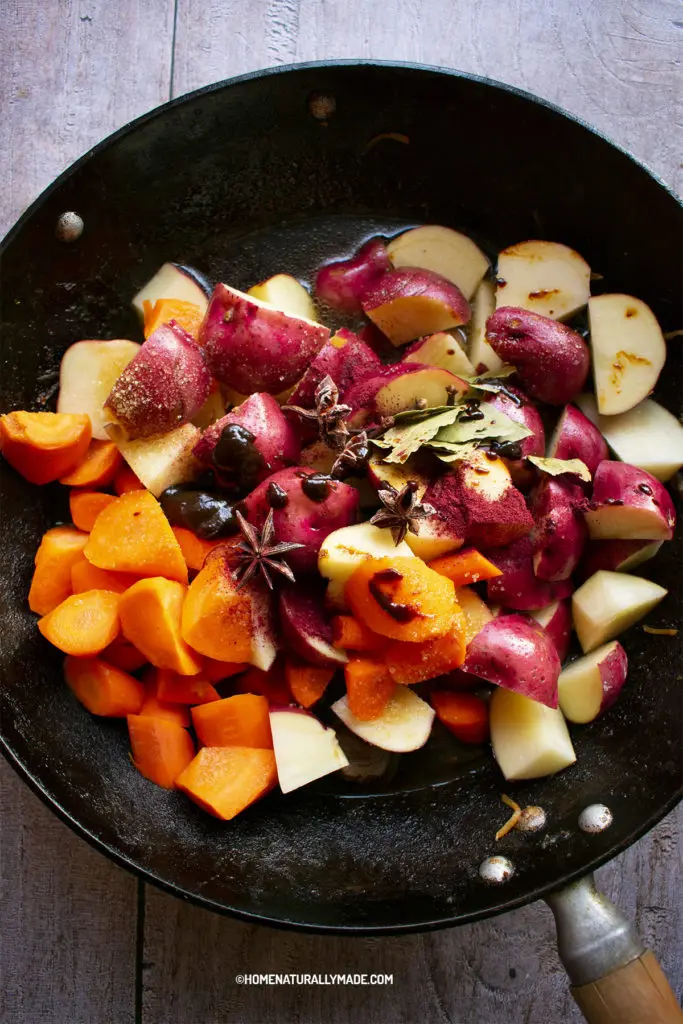 pork with potato and carrots in the wok with seasonings