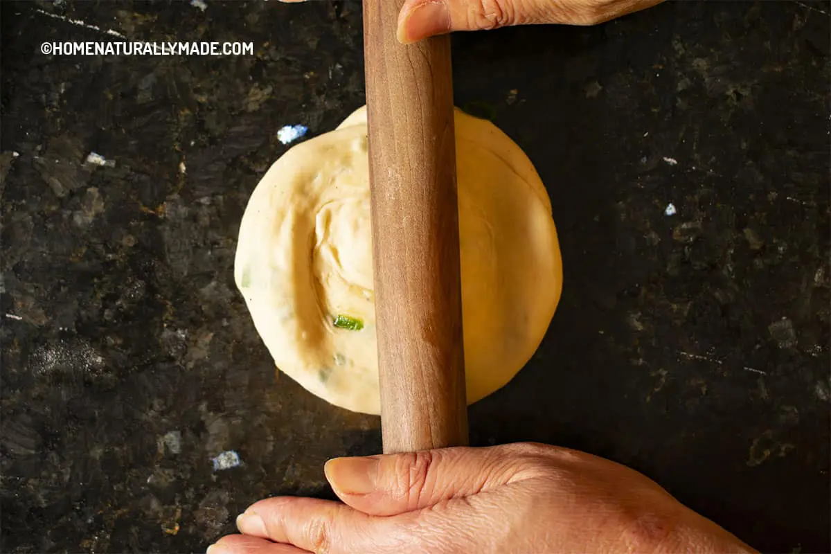 Roll a folded Scallion Pancake into a thin round circle