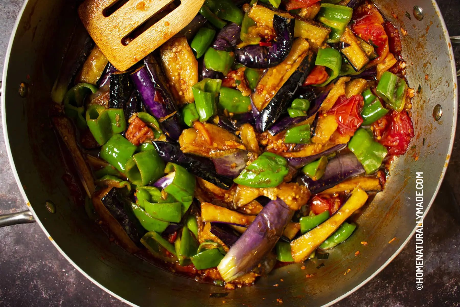 Freshly cooked Di San Xian {Stir Fried Eggplant with green pepper and tomato} in a pan