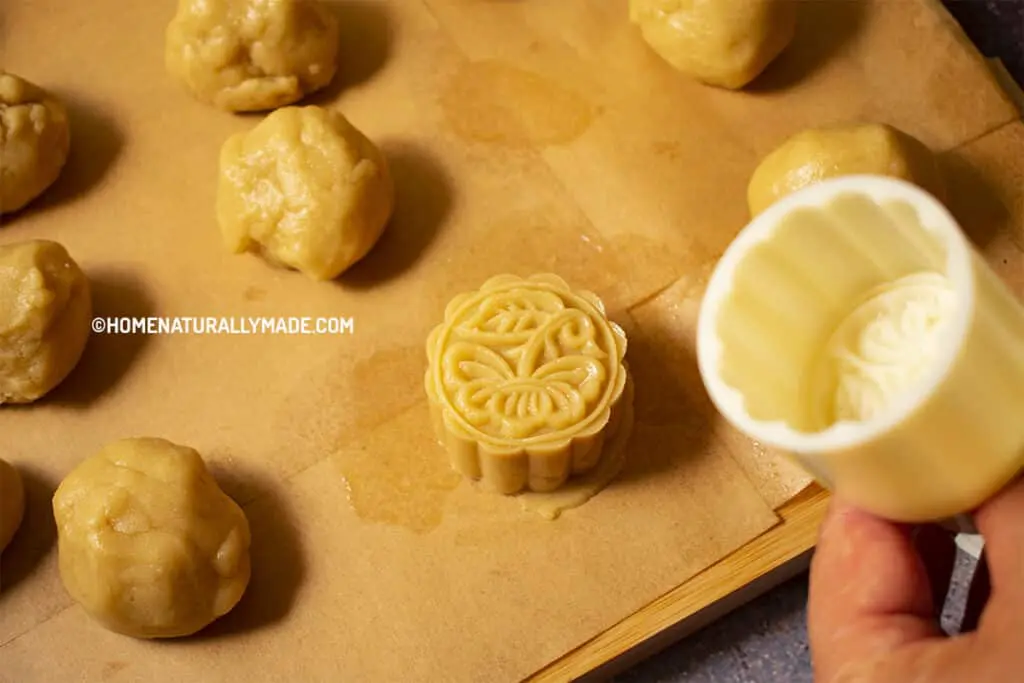 Using a mold to press mooncake