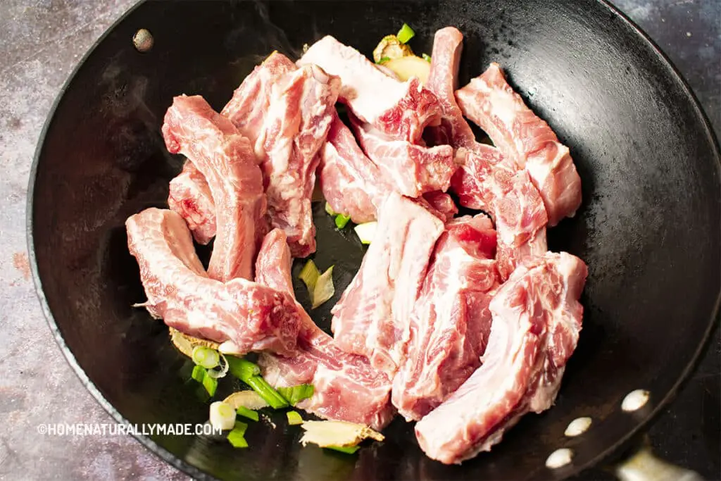 Sear the pork ribs in the wok before braising