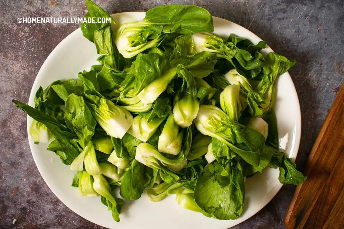 baby bok choy claened and split in half vertically on a plate