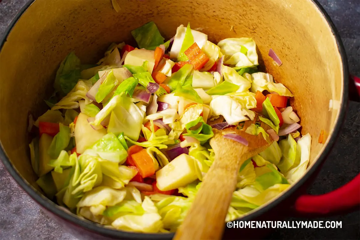 Stir Fry cabbage and other vegetables in a cast iron dutch oven