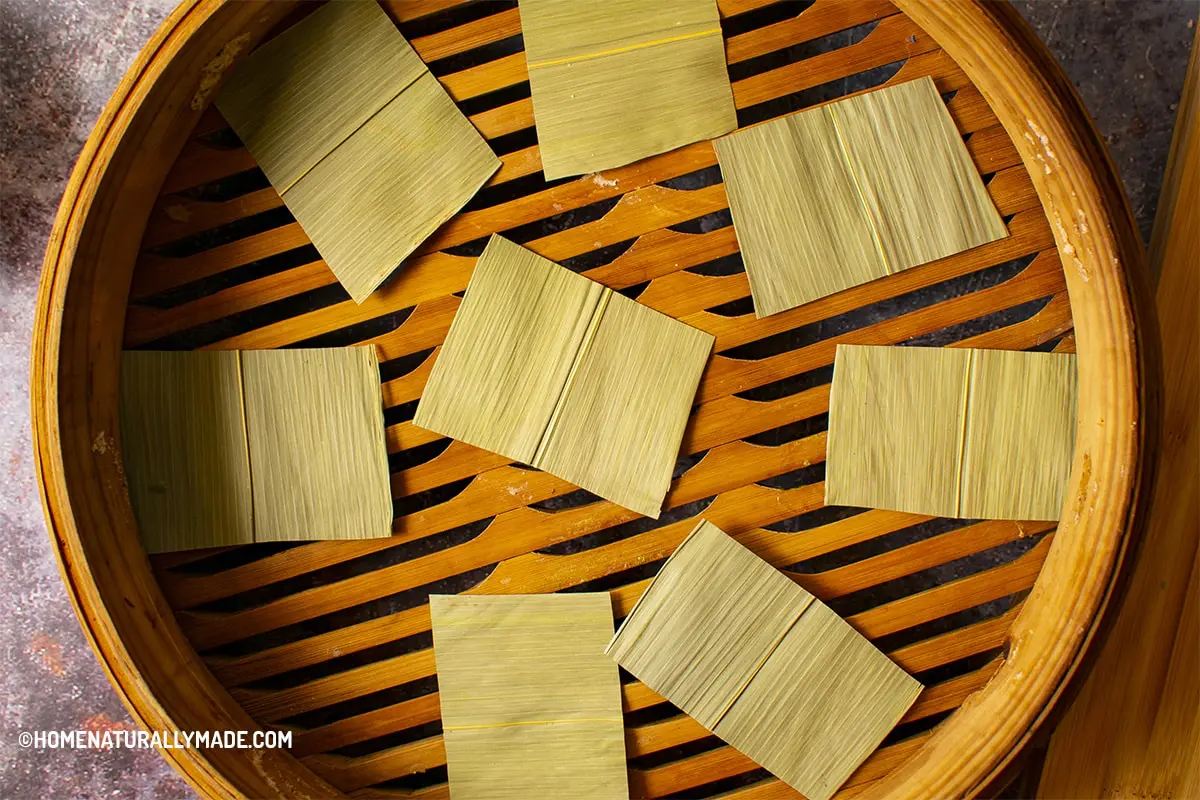 cut bamboo leaves and layer them in the bamboo steamer for steaming buns and dumplings