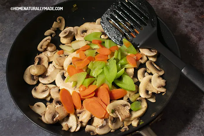 stir fry mushroom, celery and carrot slices in the fry pan