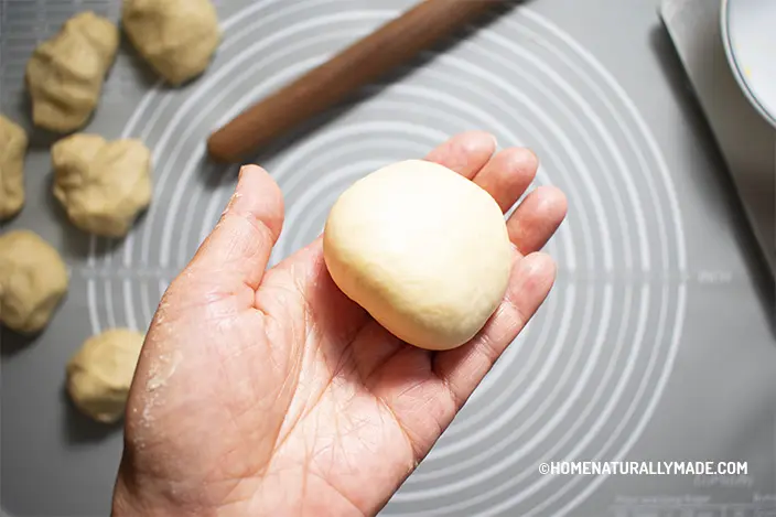 fold burger bun dough into a hollow dome shape