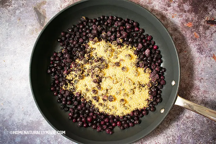 wild blueberries and turbinado sugar in the hard andozied frying pan