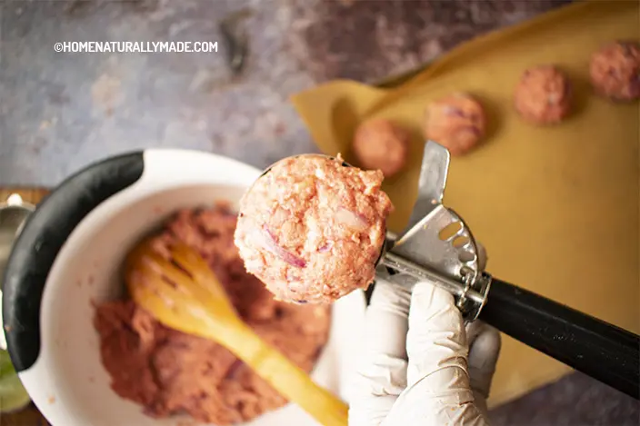 Use a ice cream scoop to scoop out marinated meat for making meatballs