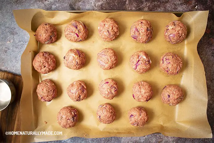 ready for baking meatballs on the unbleached parchment paper on the baking pan