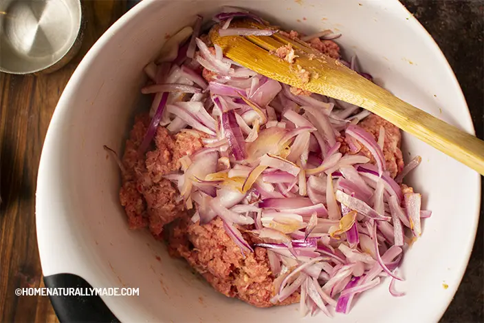 add sauteed red onion to the marinated ground beef and ground pork
