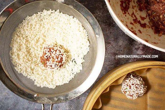 Roll the meatball in the sticky rice pile