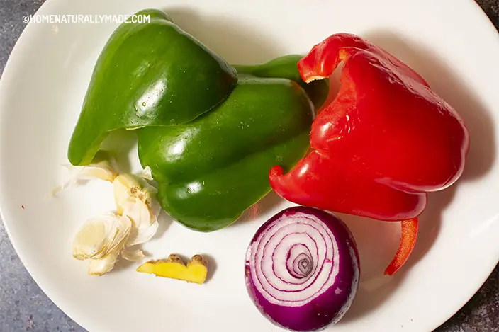 red & green bell pepper, garlic, red onion and ginger on the plate