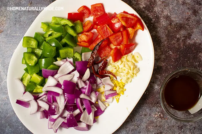 cut vegetables and herbs - green & red bell pepper, red onion, ginger and garlic