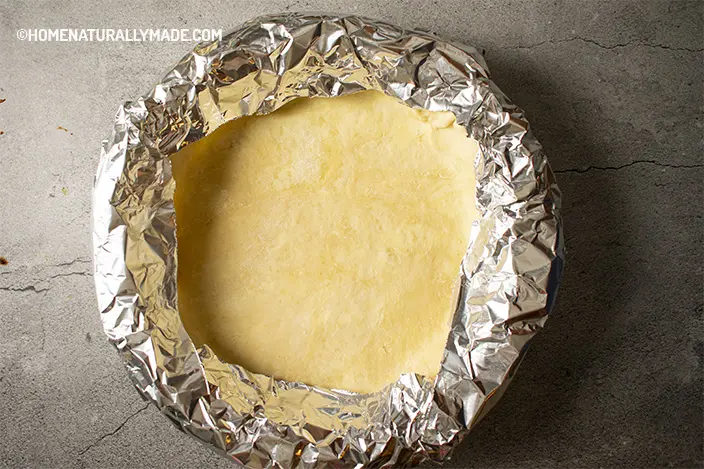wrap tin foil around the wall and edge of the pie crust for blank baking