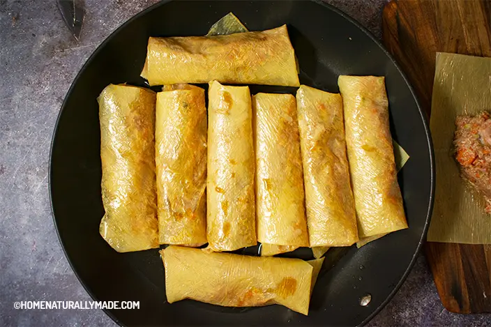 freshly wrapped tofu skin rolls in the frying pan