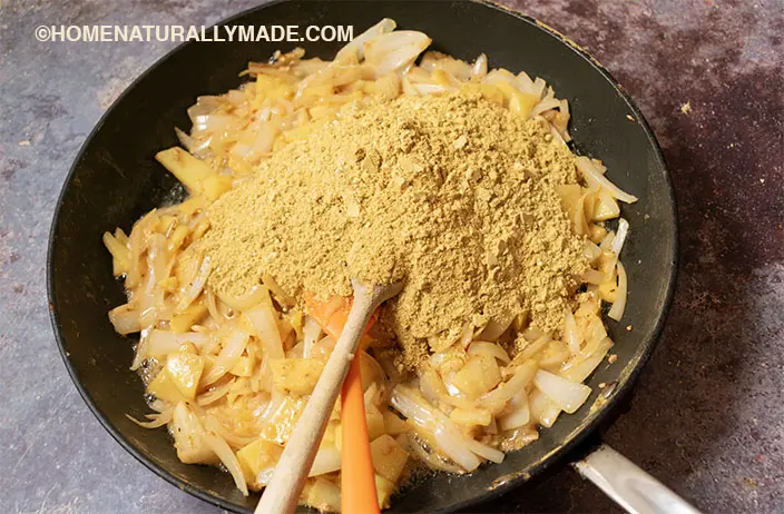 add previously toasted dry ingredients to the pan fried fresh herbs in the pan for making Curry Paste