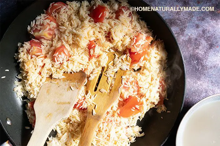 stir fry basmati rice with chopped tomatoes in the nonstick frying pan